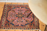Antique Lilihan square mat with softened raspberry field, bold tangerine and indigo floral geometry.