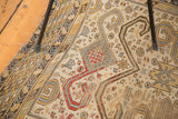 Distressed texture and geometric Perpedil and ram's horn motifs on an antique Caucasian rug.
