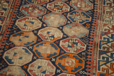 Vibrant tangerine, indigo, aqua geometric patterns with distressed foundation on antique Caucasian rug.