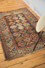 Energetic geometric arabesque main border with distressed edge on an antique Caucasian rug.