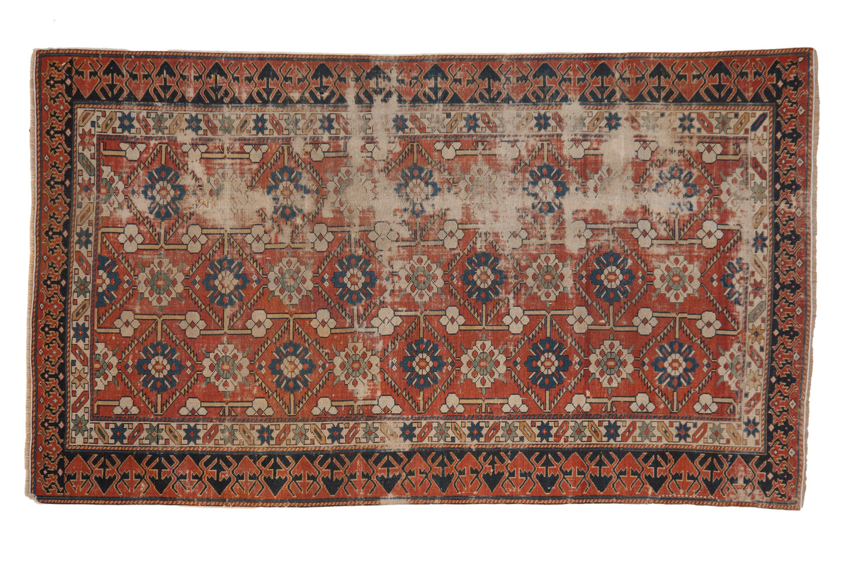 Antique distressed Caucasian rug features brick red field, splayed floral motifs, Lotto border. 3'5" x 5'11".
