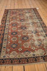 Distressed brick red field and dark Lotto inspired border on an antique Caucasian rug.