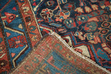 Vintage Dargazine rug corner reveals brilliant indigo, red geometric motifs, hand-knotted foundation.