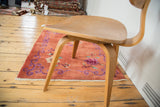 Blush peach Art Deco rug with violet purple tendrils and mint green floral branches.