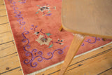 Blush peach field with floral motif and violet curvilinear border with selvage.