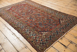 Intricate floral and vine motifs in luminous brick red, indigo, and saffron tones.