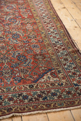 Antique Northwest Persian rug corner showing geometric borders, madder red, indigo, and new overcast fringe.