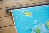 Vintage pull-down school map detail of vibrant blue Norwegian Sea and green Iceland.