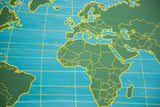Vintage Chalkboard World Map close-up: green continents, blue oceans, and yellow grid lines.