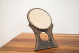 Art deco chippy dark metal stand of the Hollywood mirror, featuring circular cut-out.