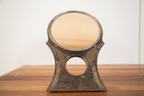 Close-up of a vintage Hollywood Mirror's round glass and art deco chippy metal stand.