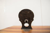 Chippy dark metal back of 1930s Hollywood mirror, showing its integrated stand and hole.