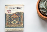 Kuba CoasterRug in packaging, highlighting geometric design in denim blue, rust, and ivory.