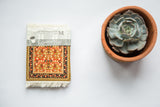 Metropolitan Museum of Art Mughal Lotus CoasterRug with red, green, and gold floral pattern.