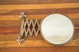 Round vintage shaving mirror with a visible corner crack and time-softened frame.