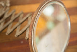 Rusty circular frame and scratched glass of the vintage shaving mirror.