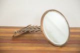 Rusted circular frame and folded accordion mechanism of the vintage shaving mirror.