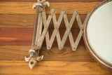 Vintage shaving mirror's rusted metal accordion extension arm.