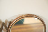 Close-up of the vintage shaving mirror showing rusted circular frame and surface scratches.