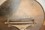 Vintage shaving mirror's rusted metal back, with 'Weber Knapp Co.' maker's mark.