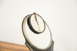 Cracked magnified mirror and art deco metal frame of the vintage Hollywood Mirror.