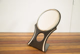 Side view of the vintage Hollywood mirror's art deco black stand with circular cutout.