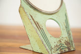 Chippy mint green paint and geometric design on the vintage Art Deco mirror stand.
