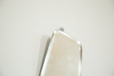 Subtle spotted discoloration on the beveled glass of an antique mirror.