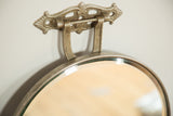 Ornate Victorian metal hardware and beveled glass edge detail on antique mirror.