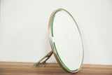 Victorian mirror's beveled glass edge and aged silver-toned metal frame.