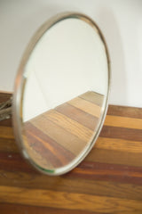 Antique Victorian barber mirror's reflective beveled edge and ornate hardware.
