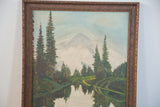 Vintage landscape painting with evergreen trees, reflected water, and ornate gold frame.