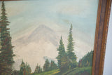 Evergreen trees, hazy mountain peak, and carved brown frame of a vintage painting.