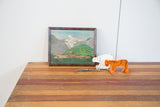 Folk art oil painting in its dark wood frame, styled for tabletop display.