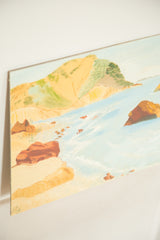 Mid century seascape detail with vibrant blue water, sandy beach, and rust rocks.