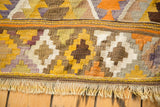 Patterned edge and yellow, orange, lavender fringe of the vintage Kilim rug.