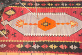 Vintage Kilim rug detail with vibrant lavender field, orange geometric motif, and red borders.