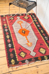 Geometric lavender, cranberry, orange, and black patterns on a vintage Kilim corner.