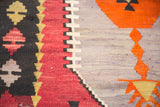 Geometric stepped patterns in cranberry red and lavender on a vintage Kilim rug.