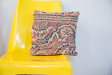 Vintage Persian rug pillow featuring muted floral motifs and geometric borders.
