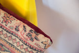 Vintage Persian rug pillow corner, showing Kerman fragment's woven back and burgundy velvet edge.