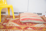 Oversized pillow with faded red and pale green Kilim stripes.