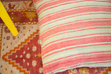 Woven texture of faded red and green striped handmade Moroccan Kilim pillow.