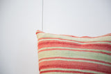 Handwoven texture of faded pink and green stripes on a Moroccan Kilim pillow.