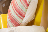 Faded pink and light green striped Moroccan Kilim pillow with handwoven texture and natural canvas.