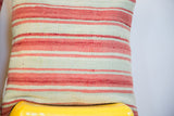 Woven texture of faded reddish-pink and light green striped Moroccan Kilim pillow.