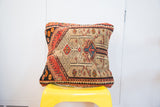Hand-knotted vintage Persian rug fragment pillow, central camel and blue geometric burst.