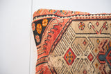 Hand-knotted texture and geometric red, charcoal, camel pattern on a Persian pillow.