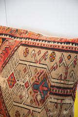 Northwest Persian rug fragment pillow with camel, red, charcoal, and blue tribal motifs.