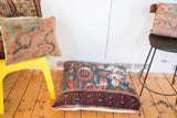 Aged antique Lilihan rug pillow with dark blue, red border, and golden velvet backing.